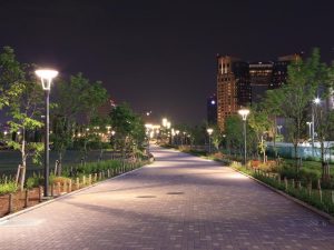 A city park pathway in the evening, with the pathway lights turned on